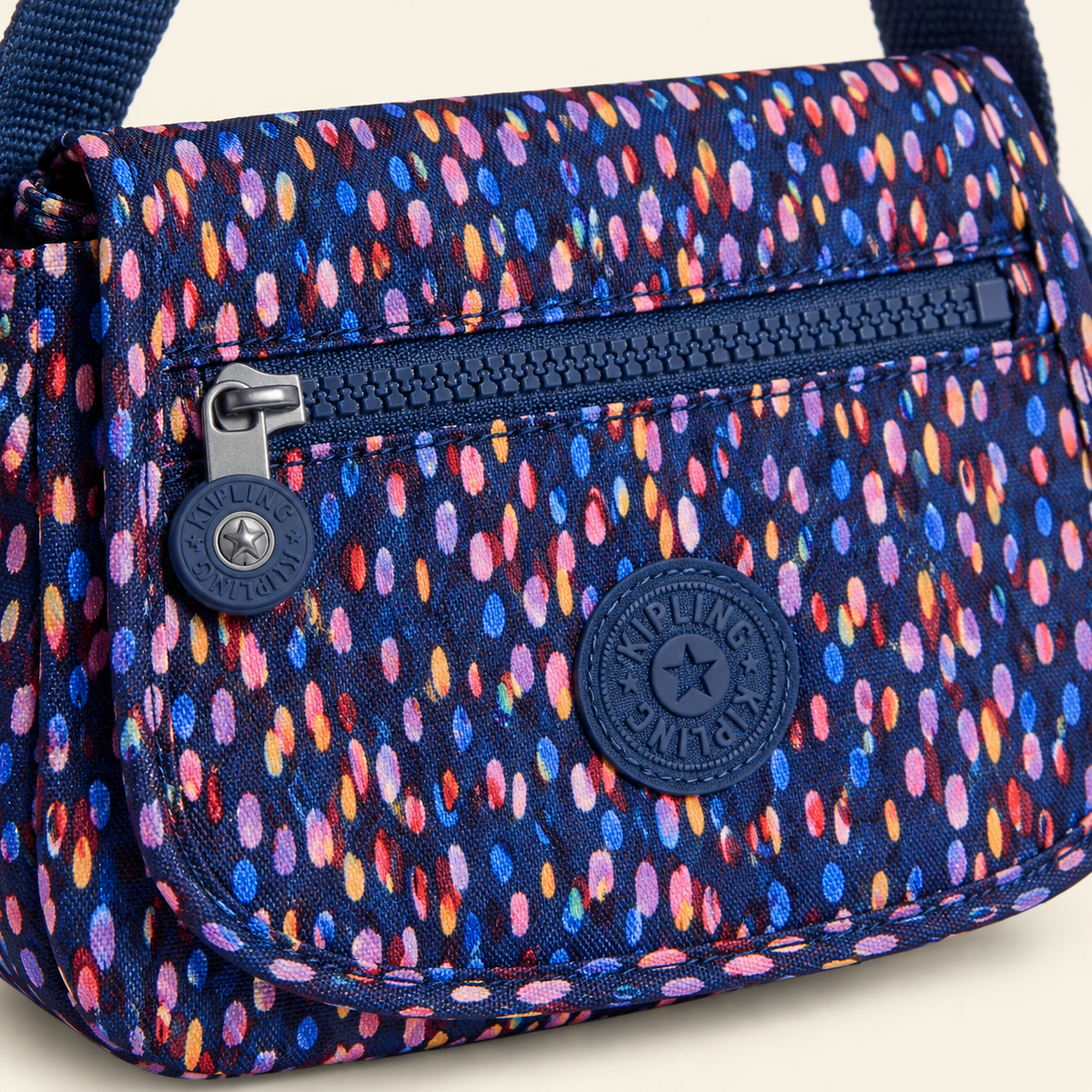 Detalle del estampado multicolor, logo y bolsillo con cierre del bolso Kipling