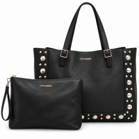 Tote Steve Madden negro grande con tachas metálicas y estuche incluido sobre fondo blanco